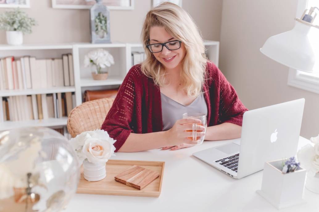 Woman at a desk with laptop, engaged in ongoing evaluation and optimization using knowledge management software.